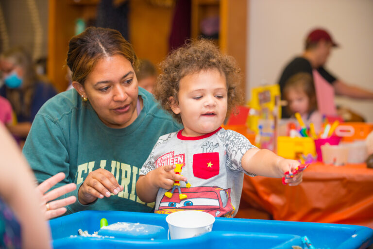 Image of child playing with adult watching